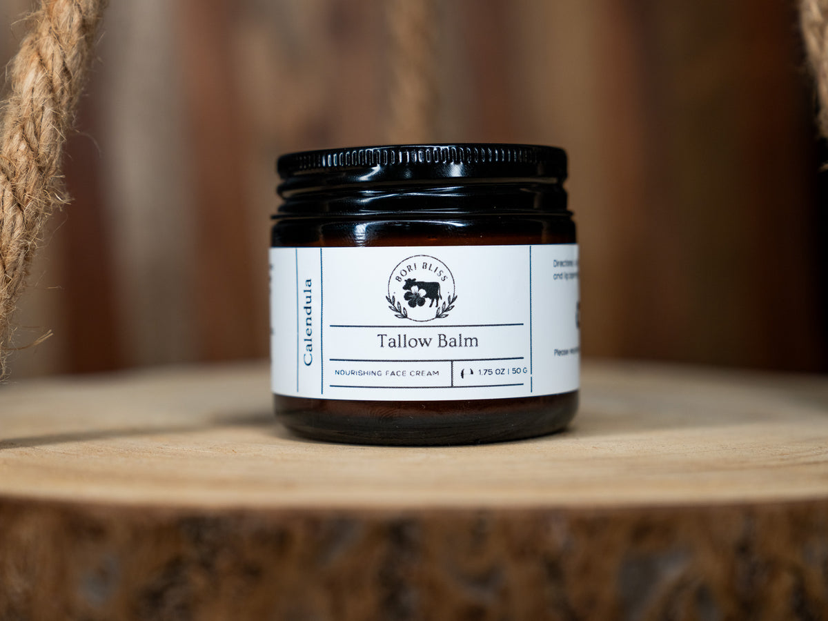 A mini 1.75oz jar of Bori Bliss Tallow Face Balm shown with natural calendula flower ingredients.
